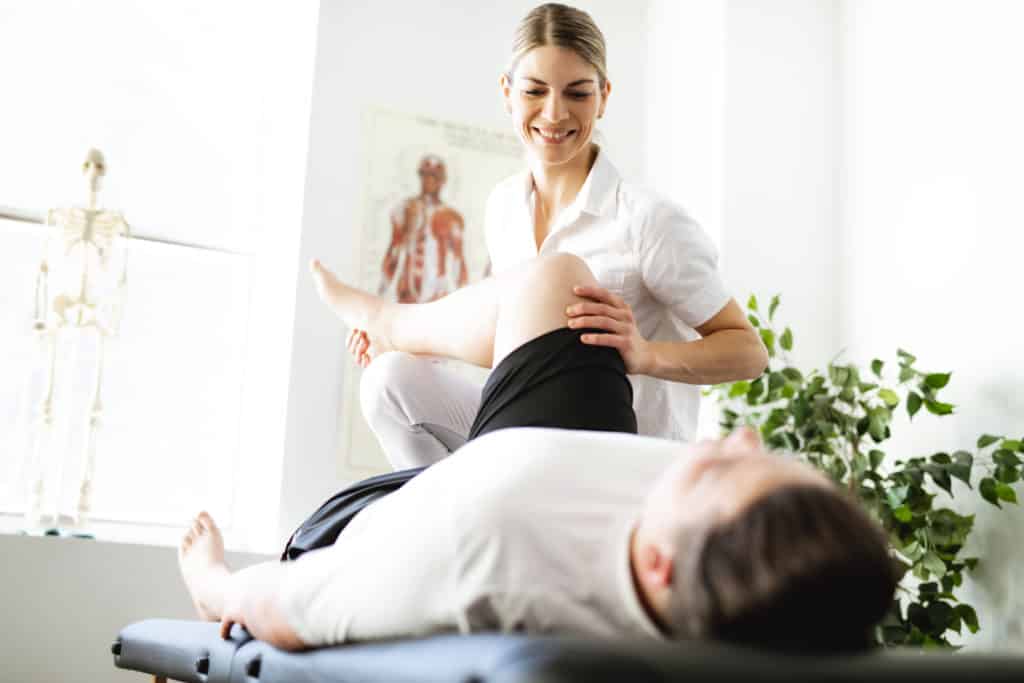 Modern rehabilitation physiotherapy woman worker with client